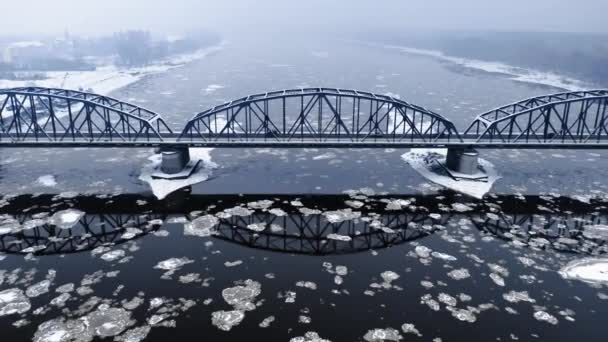 Rivière froide avec floes et pont enneigé. Hiver en Pologne. — Video