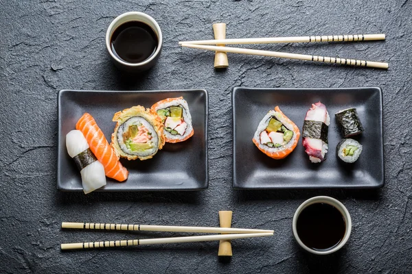 Sushi für zwei Personen, serviert in schwarzer Keramik — Stockfoto