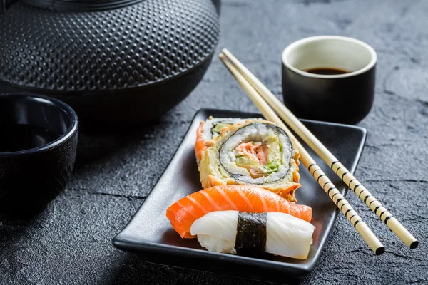 Fresh sushi served in a black ceramic — Stock Photo, Image