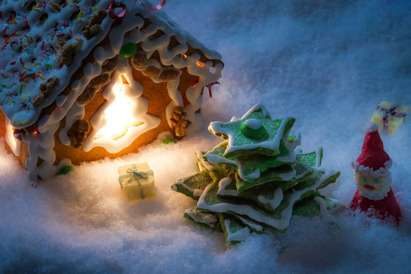 Peperkoek huis met sneeuwpop en santa — Stockfoto