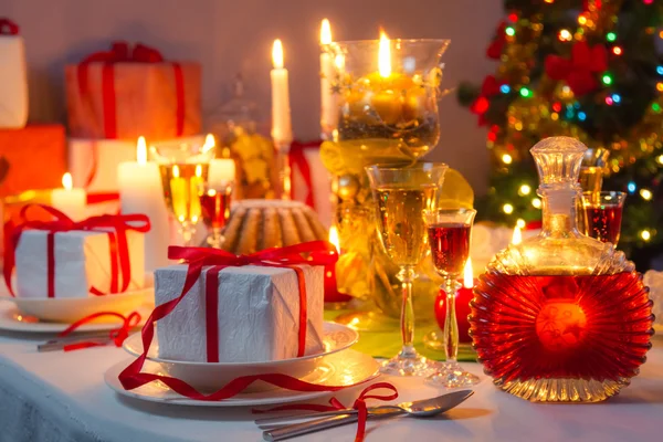 Luz de velas e presentes por toda a mesa de Natal — Fotografia de Stock