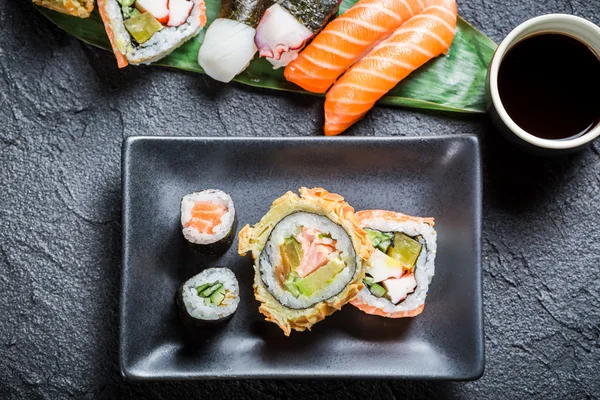 Sushi mit Sojasauce auf schwarzem Stein — Stockfoto