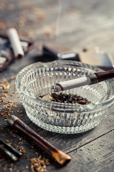 Выкуривая сигарету в старой трубе — стоковое фото