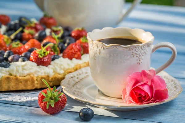 Detailní záběr na kávu a koláč s jahodami a borůvkami — Stock fotografie