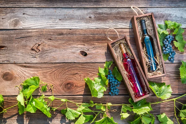 Different types of wine in a wooden box and grapes — Stock Photo, Image