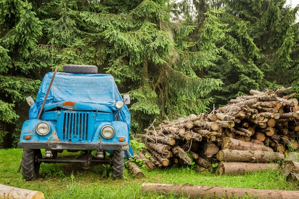 Velho carro azul nas montanhas perto da floresta — Fotografia de Stock