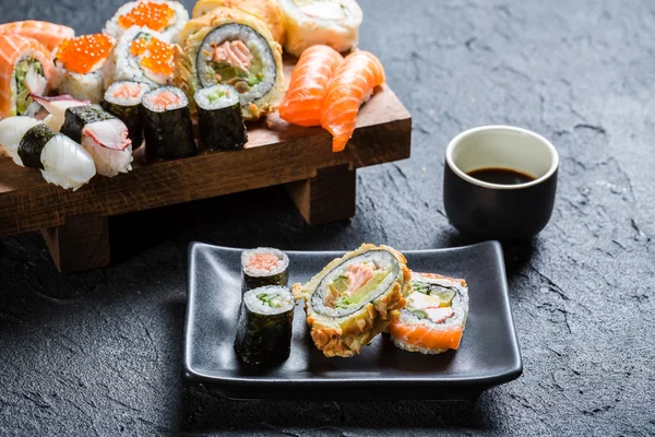 Sushi servido com molho de soja em pedra preta — Fotografia de Stock