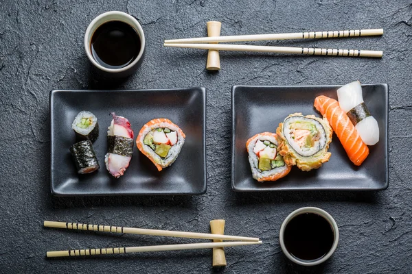 Sushi für zwei Personen auf schwarzem Stein serviert — Stockfoto