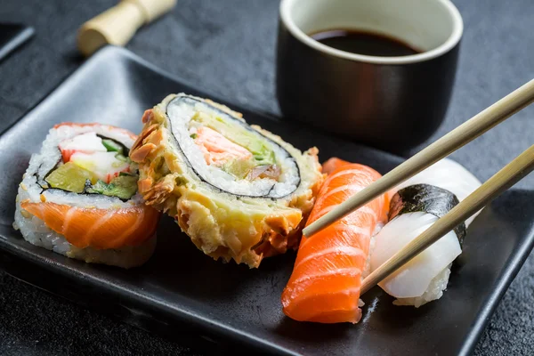 Närbild av sushi som äts med pinnar — Stockfoto