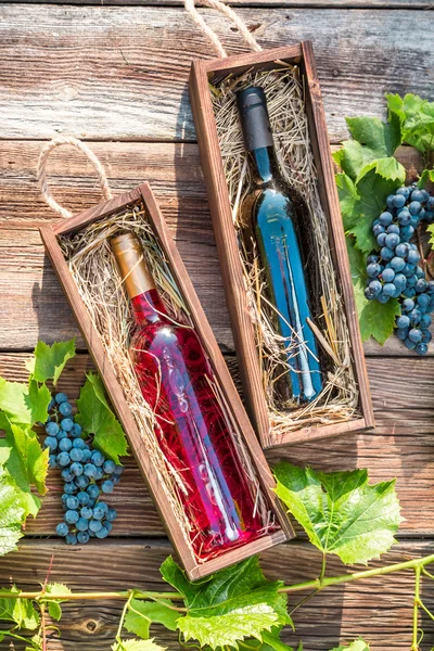 Different types of wine in a wooden box and grapes — Stock Photo, Image