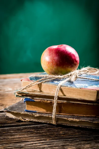 Livres anciens et pomme sur le bureau de l'école — Photo