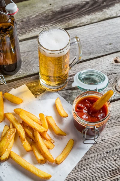 Primer plano de papas fritas frescas caseras con cerveza fría —  Fotos de Stock