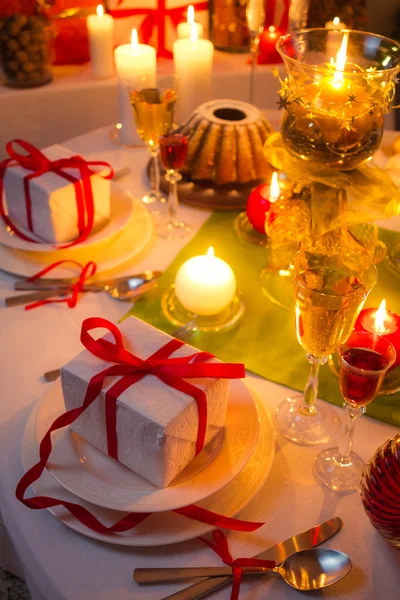 Lumière des bougies et cadeaux tout autour de la table de Noël — Photo