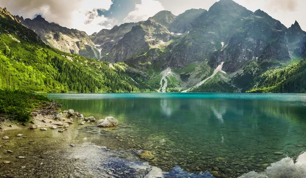 Lago de montaña cristalina y montañas rocosas Imágenes de stock libres de derechos