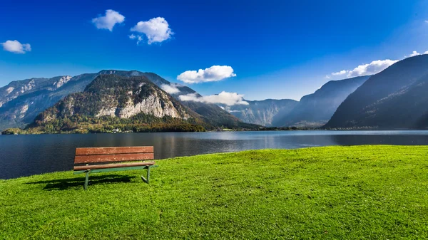 Dřevěná lavička u jezera mezi horami — Stock fotografie