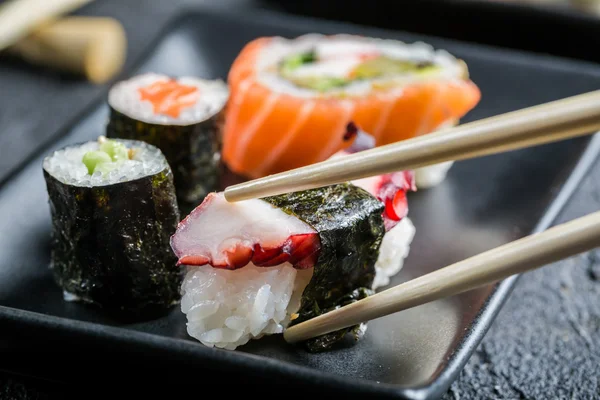Closeup of sushi eaten with chopsticks
