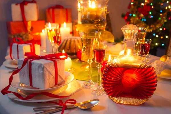 Luz de velas e presentes por toda a mesa de Natal — Fotografia de Stock