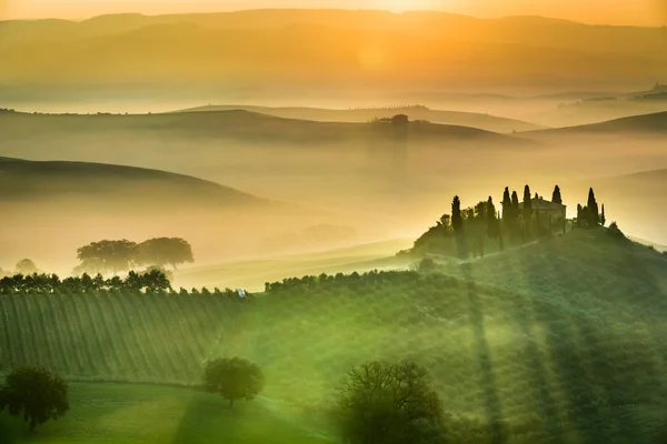Zonsopgang boven de groene velden in Toscane — Stockfoto