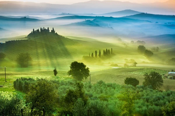 Zonsopgang boven de groene velden in Toscane — Stockfoto