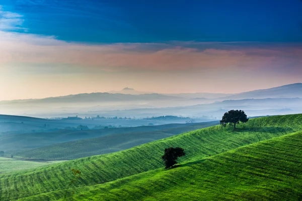 Salida del sol sobre un valle verde en Toscana — Foto de Stock
