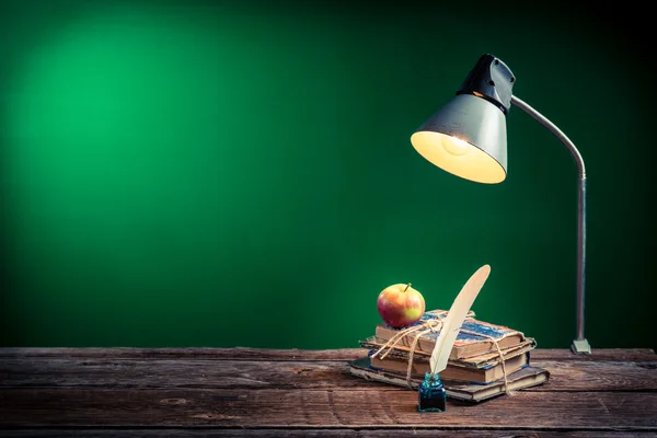 Lamp, books and apple in the classroom on blackboard background — Stock Photo, Image
