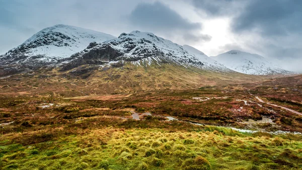 Voetpad tussen besneeuwde bergen — Stockfoto