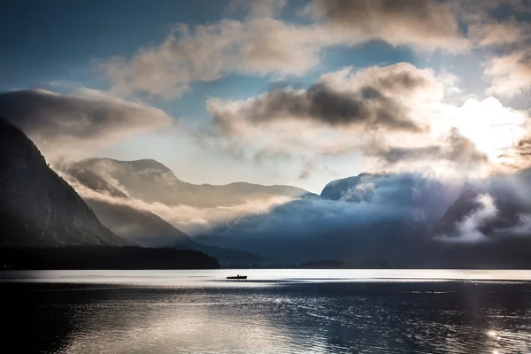 Pequeño barco en el lago de niebla en las montañas —  Fotos de Stock