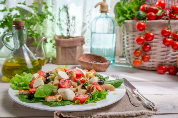 Frühlingssalat in einer sonnigen Küche voller Gemüse — Stockfoto