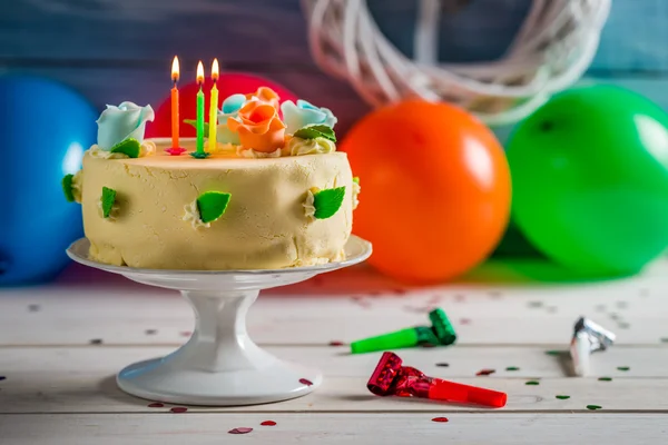 Lighted candles on birthday cake — Stock Photo, Image