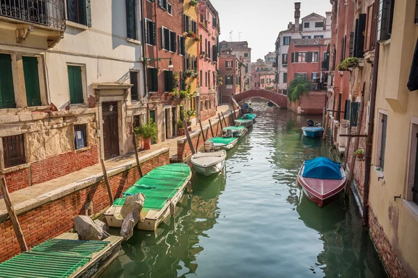 Båter og motorbåter på en kanal i Venezia stockfoto