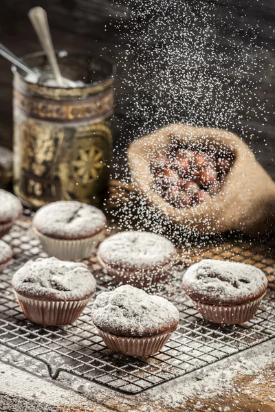 Zucchero a velo che cade sui muffin al cioccolato fresco — Foto Stock