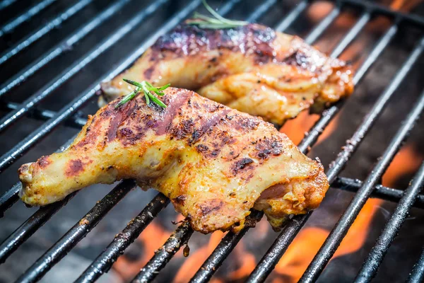 Roasted chicken legs on the grill with fire — Stock Photo, Image