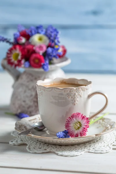 Šálek horké kávy a jarních květin — Stock fotografie