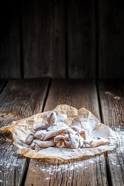 Alitas de ángel con azúcar en polvo sobre papel de hornear —  Fotos de Stock