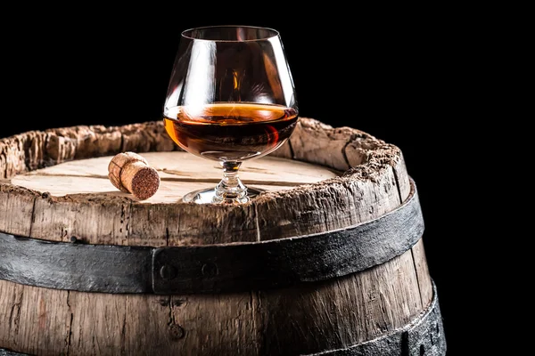 Glass of cognac on old wooden barrel — Stock Photo, Image