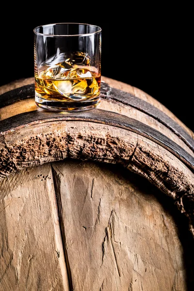 Vidrio de whisky con hielo en barril de madera viejo —  Fotos de Stock