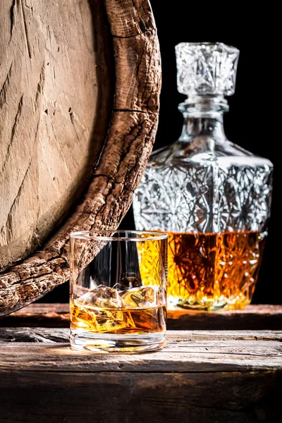 Glass of aged whisky with ice and carafe — Stock Photo, Image