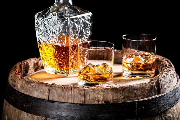 Two glasses of aged whiskey or brandy on the rocks — Stock Photo, Image