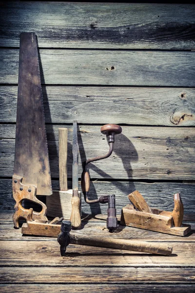Martello, sega e scalpello su vecchio tavolo di legno — Foto Stock