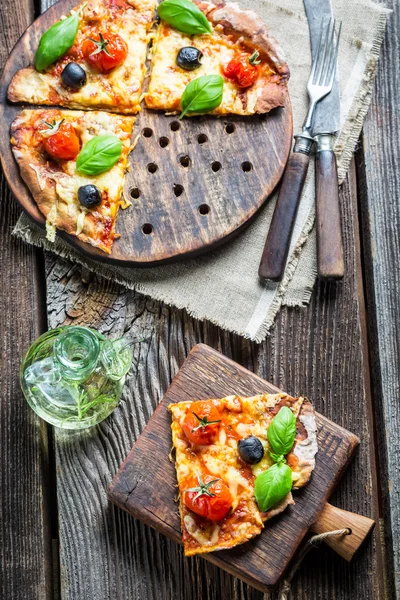 Closeup of baked pizza with olives and tomatoes — Stock Photo, Image