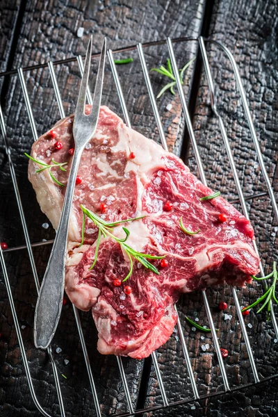 Fresh piece of red meat with rosemary and pepper — Stock Photo, Image