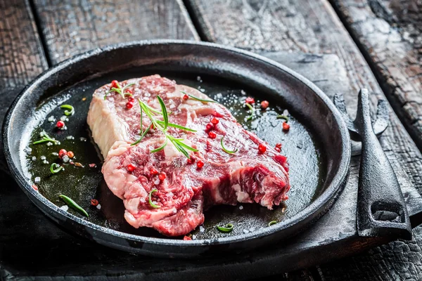 Closeup of beef with rosemary and pepper ready to grill — Stock Photo, Image