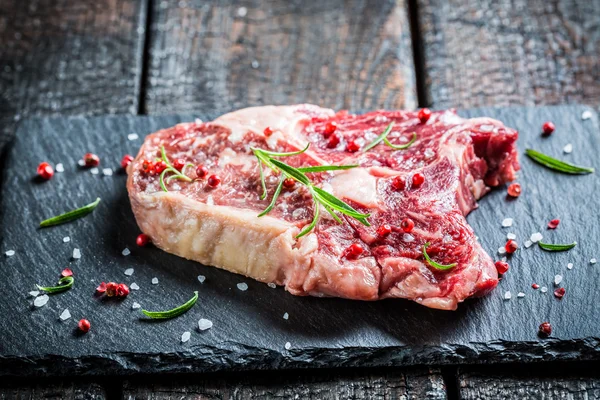 Beef with rosemary and pepper on black rock — Stock Photo, Image