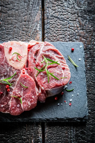 Meat with fresh herbs on a stone plate — Stock Photo, Image