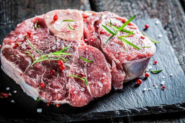 Carne com ervas frescas na rocha preta — Fotografia de Stock