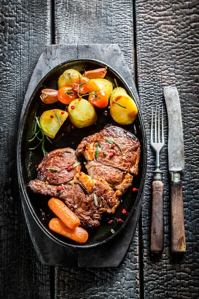 Bife assado e legumes com ervas no prato de churrasco — Fotografia de Stock