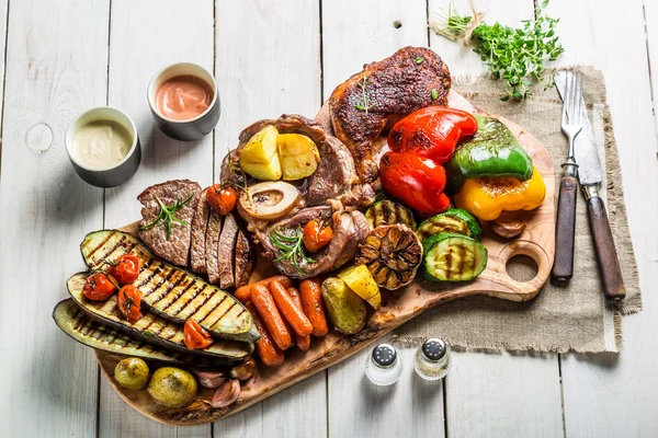 Gegrilde biefstuk en groenten met zout op houten bord — Stockfoto