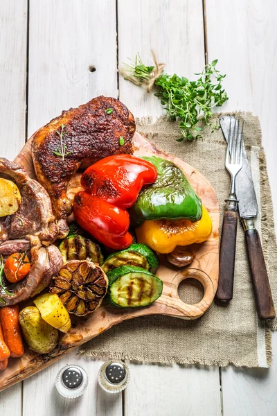 Grillad biff och grönsaker med salt på vitt bord — Stockfoto