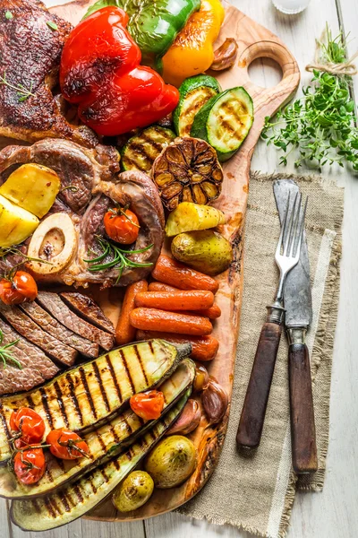 Grillezett zöldségek és gyógynövények fából készült táblán steak — Stock Fotó
