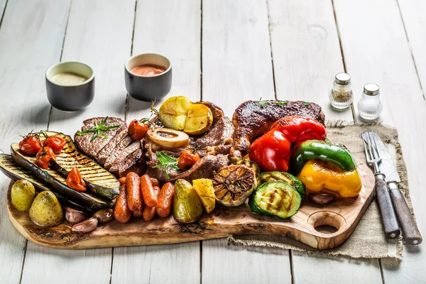 Grillad biff och grönsaker med salt på träskiva — Stockfoto